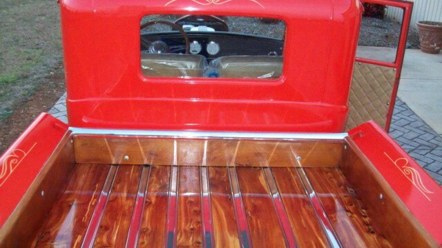 Red truck bed with wood planks.