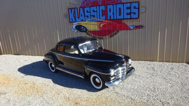 Black classic car at Klassic Rides shop.