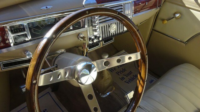 Classic Plymouth car interior, wooden steering wheel.