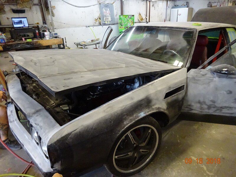 Gray primered classic car under repair.
