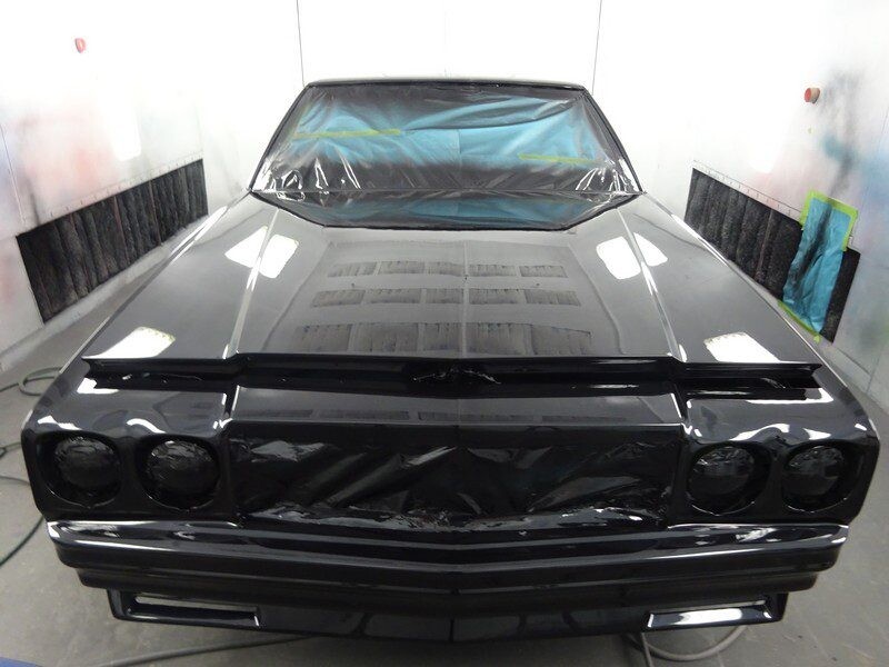 Black classic car in paint booth.