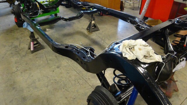 Black car chassis on jack stands.