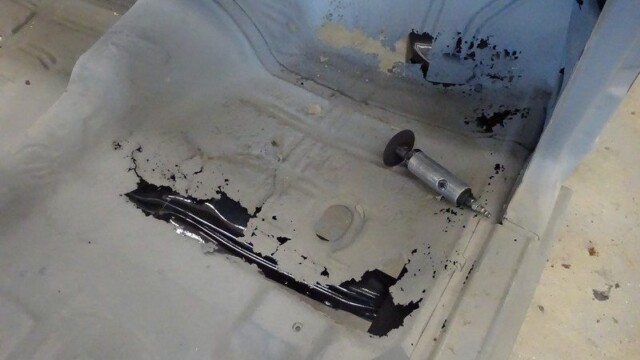 Car floor rust repair in progress.