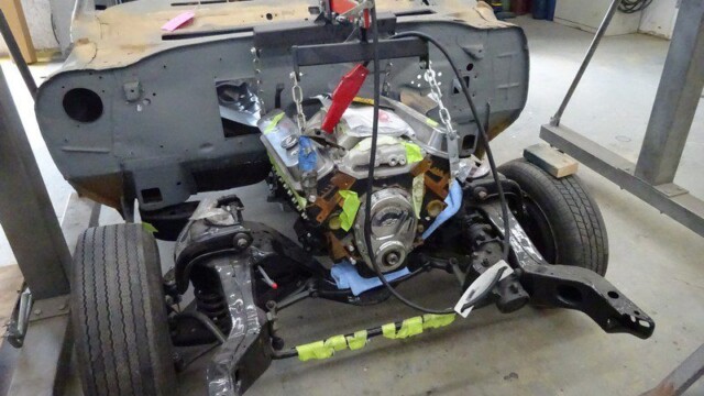 Classic car engine installation in progress.