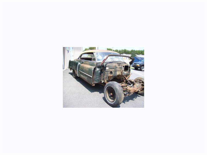 Here's an alt tag for the image: `Classic car restoration project, partially disassembled.`