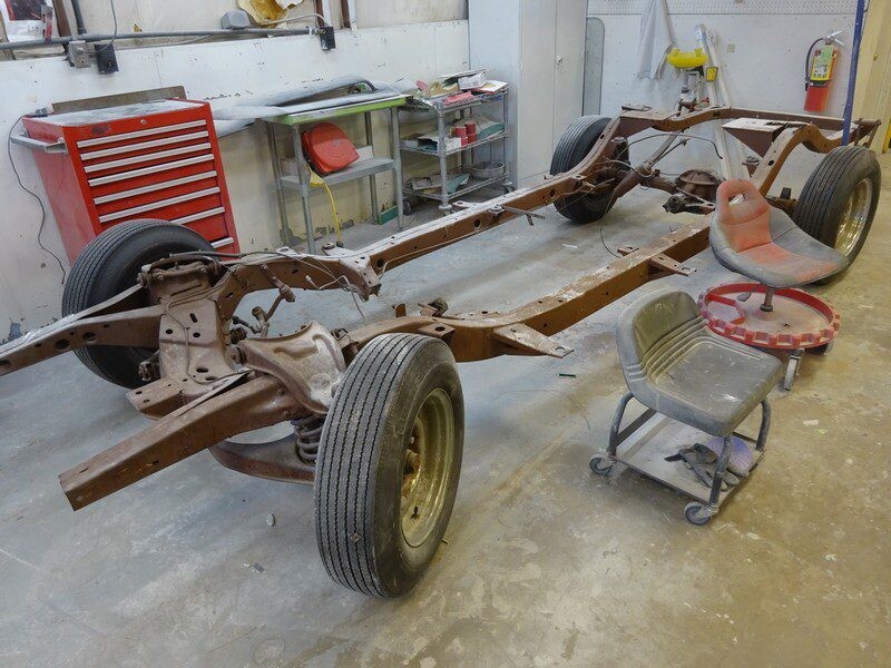Rusty car chassis in auto shop.