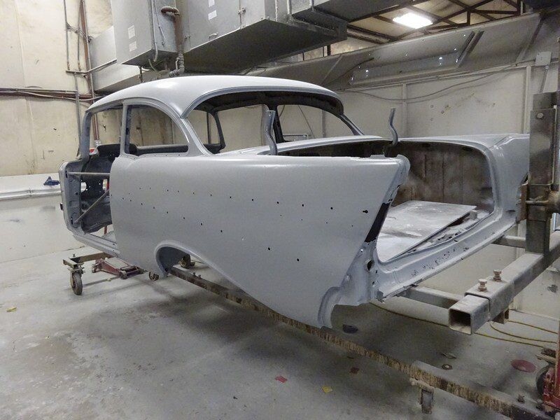 Primered vintage car body in shop.