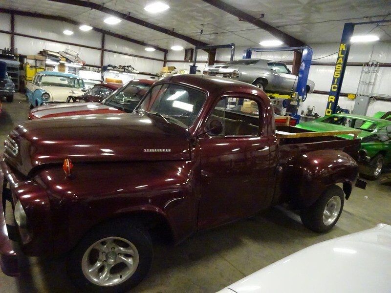 Maroon classic pickup truck in garage.