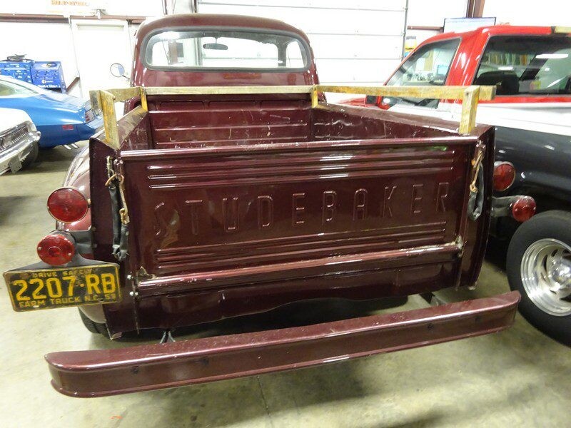 Here's an 8-word alt tag for the image: Vintage maroon Studebaker truck rear view.