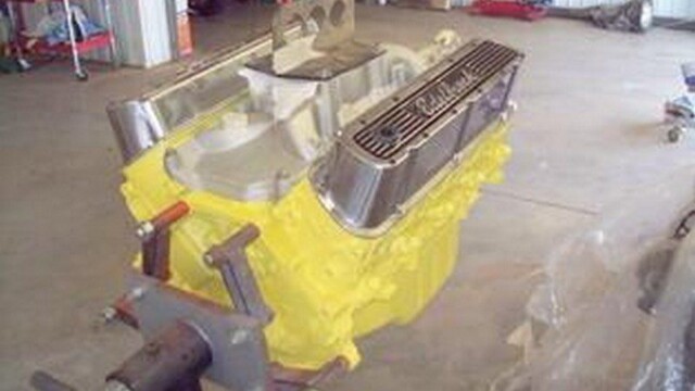 Yellow painted engine block on stand.
