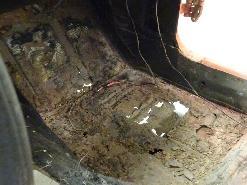 Severely rusted car floor needs repair.