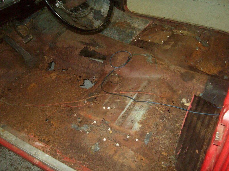 Severely rusted car floor needs repair.
