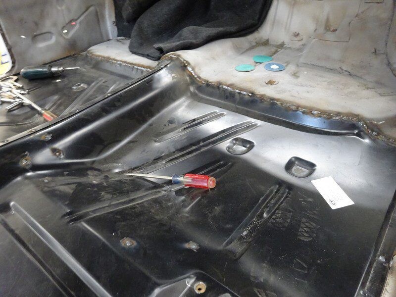 Car floor panel repair in progress.