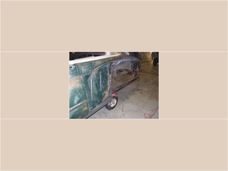 Here's an alt tag for the image: `Classic car undergoing restoration work.`