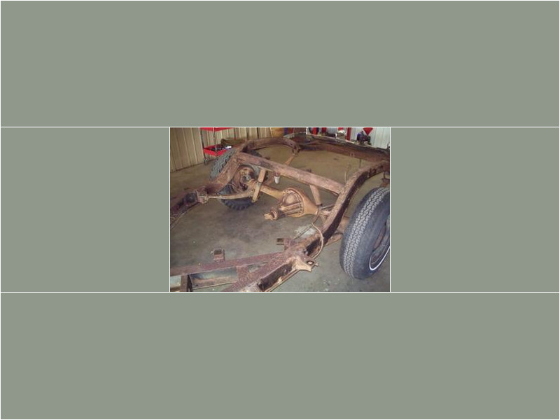 Here's an alt tag for the image: Rusty vintage car chassis in garage.