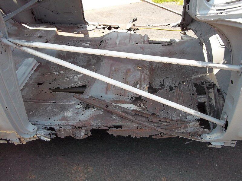 Severely rusted car floor needs repair.