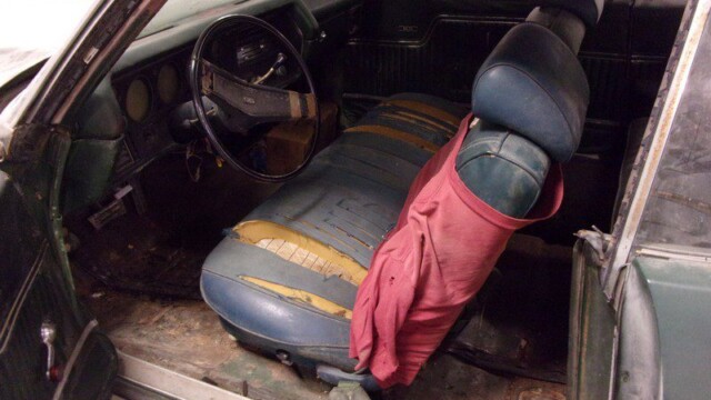 Here's an alt tag for the image: Damaged classic car interior.