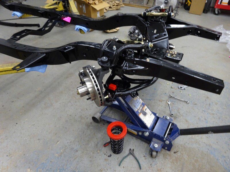 Black car chassis on jack stand.