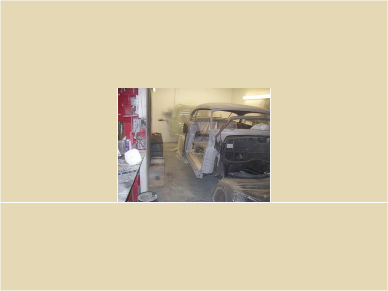 Here's an alt tag for the image: Classic car undergoing restoration in a workshop.