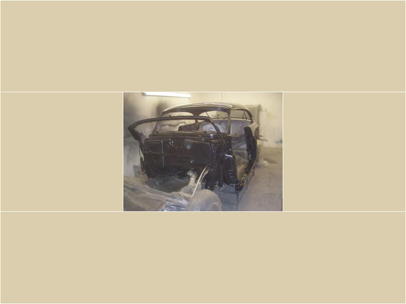 Here's an alt tag for the image: Black classic car under restoration.
