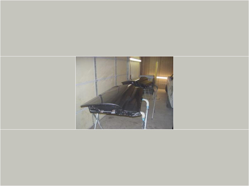 Here's an alt tag for the image: Two car doors drying in paint booth.