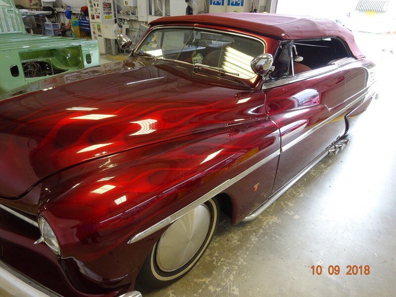 Red custom Mercury convertible with flames.