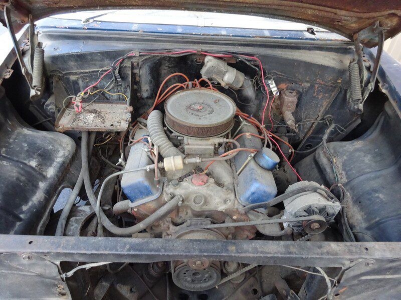 Here's an alt tag for the image: Rusty classic car engine bay.