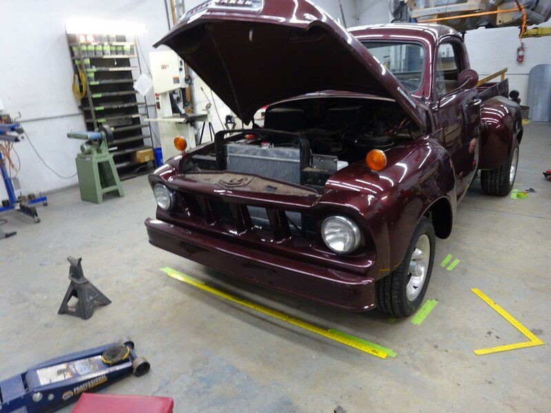 Maroon classic truck under repair.