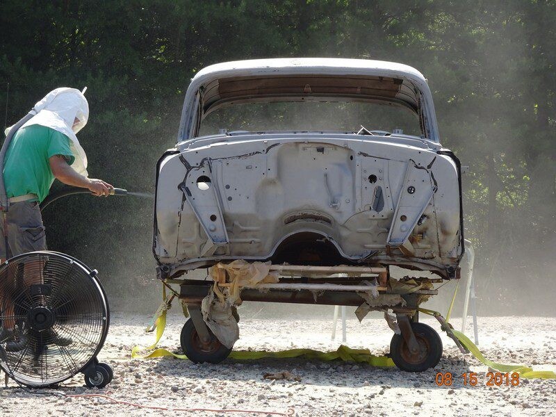 Sandblasting a vintage car body.