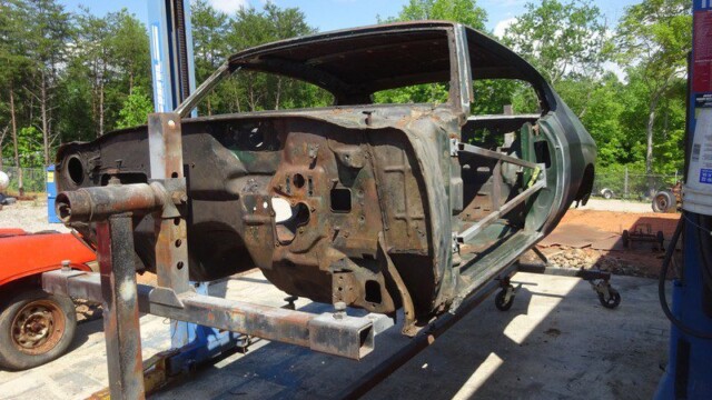 Rusting vintage car body in repair.