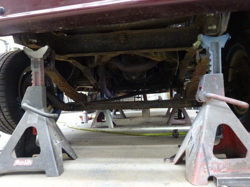 Car's undercarriage on jack stands.