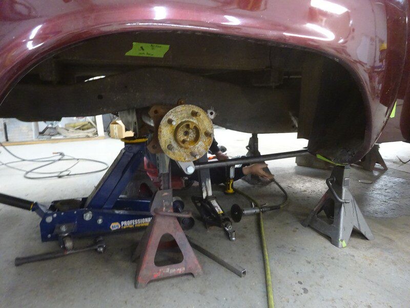 Car underside repair on jack stands.