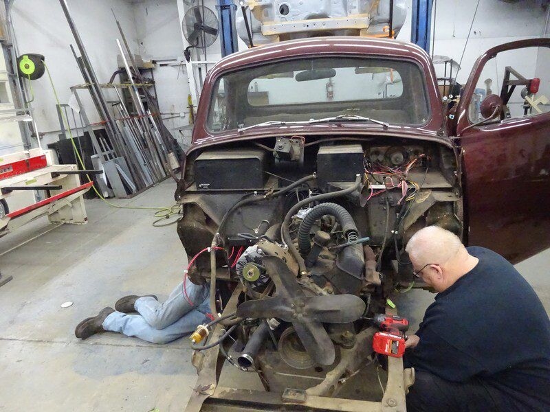Mechanics repairing vintage truck engine.