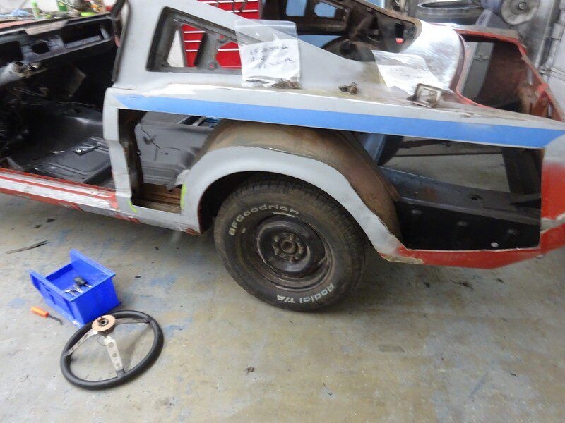 Red classic car body restoration progress.