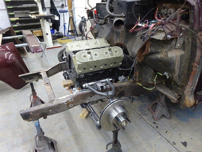 Classic car engine being installed.