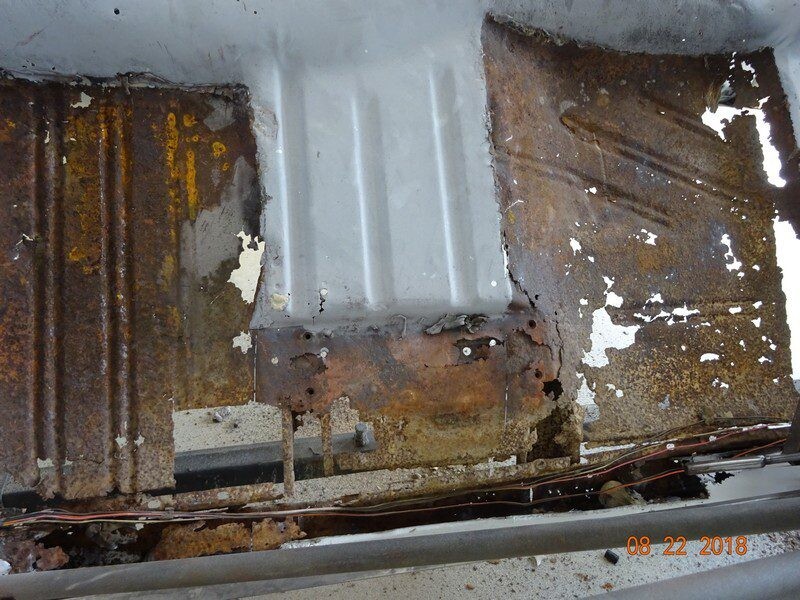 Severely rusted car floor panel.
