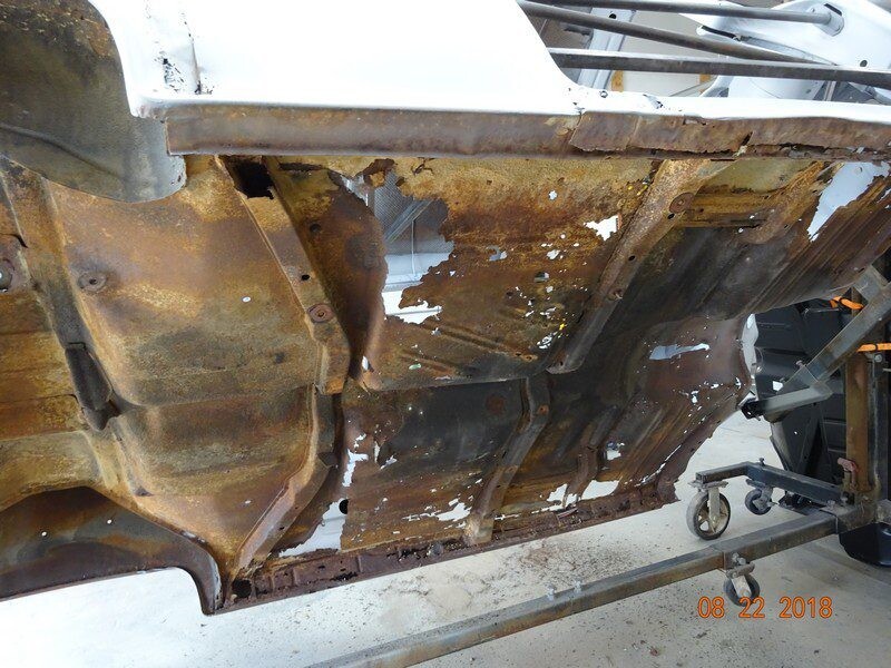 Rusty car body undergoing restoration.
