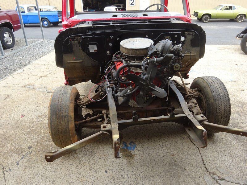 Red truck chassis, engine exposed.