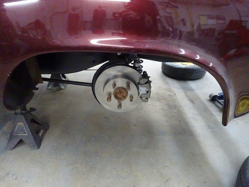 Car's rear disc brake assembly detail.