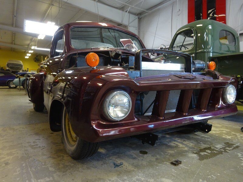 Custom maroon vintage truck in shop.