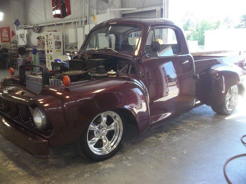 Maroon vintage pickup truck in garage.