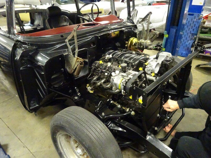 Classic car engine being installed.