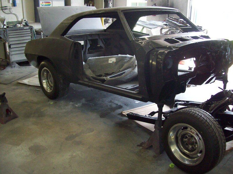 Black Camaro body restoration in progress.