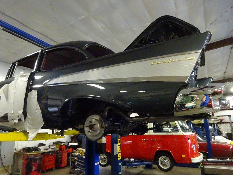 Here's an 8-word alt tag for the image: Classic dark-grey Bel Air on car lift.