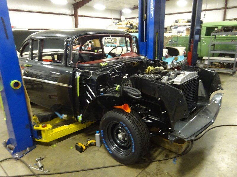 Black classic car under repair in garage.