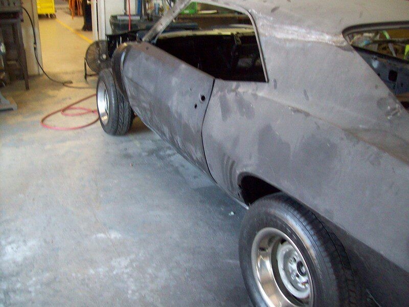 Gray muscle car in auto body shop.