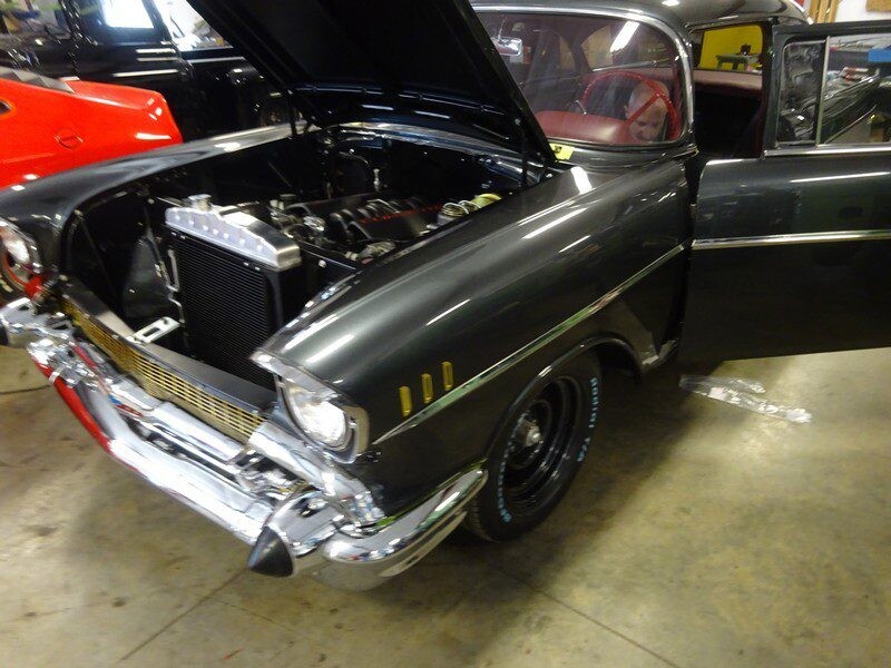 Dark gray 1957 Chevy with hood open.