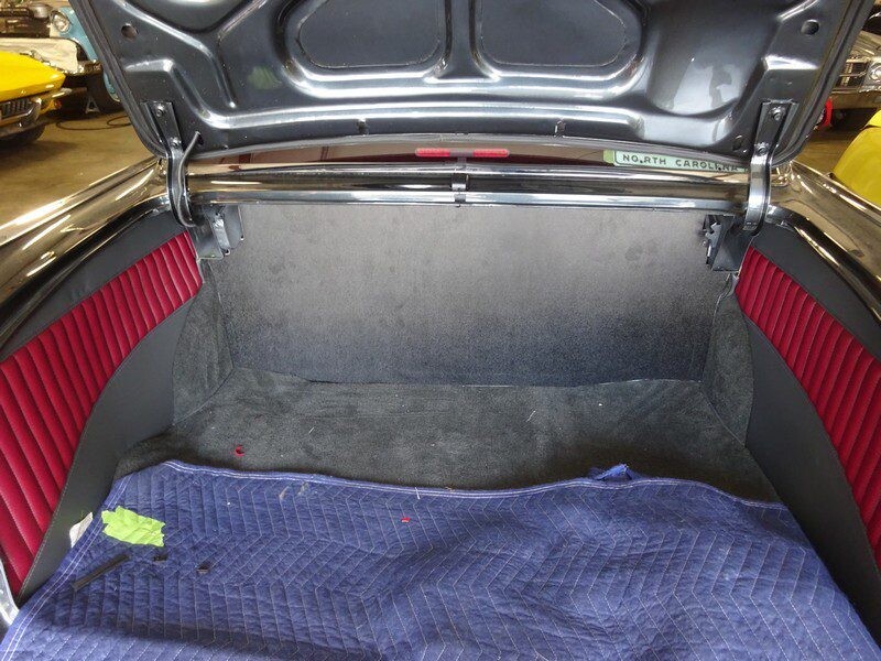 Classic car trunk, red interior.