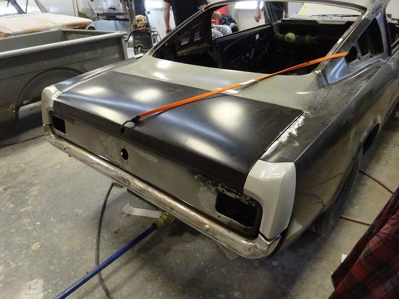 Here's an alt tag for the image: Rear of classic Mustang undergoing restoration.
