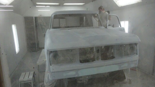 Truck in paint booth, getting sprayed.